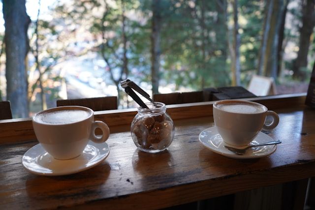 Two cups of coffee by the window, forest in background
