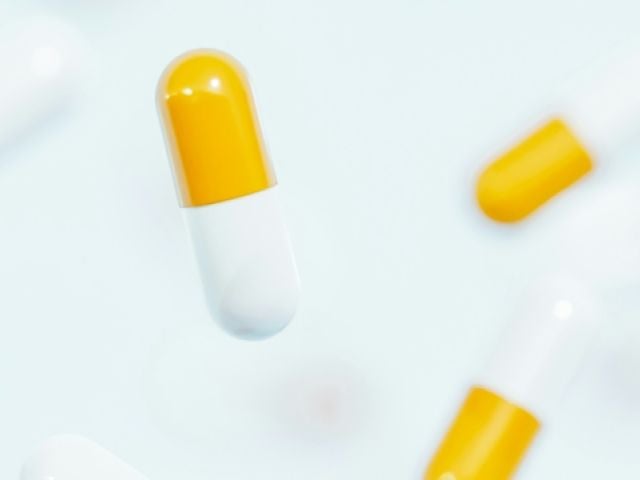 Boswellia Benefits for Inflammation, Side Effects and Dosage 10 Yellow and white turmeric capsules falling against a light blue background.