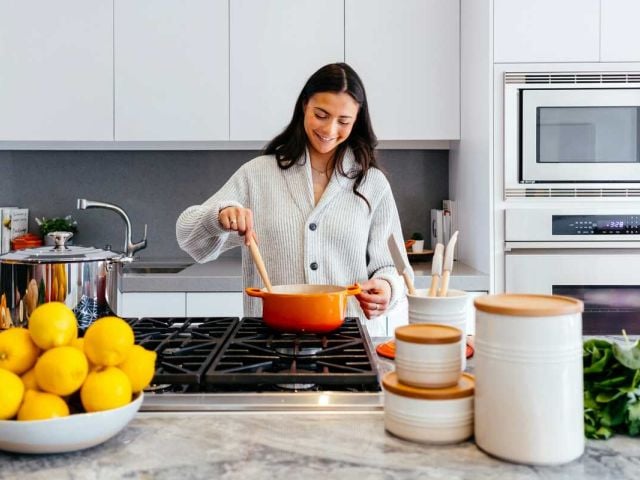 A woman prepares a heart-healthy meal for reducing ApoB levels.