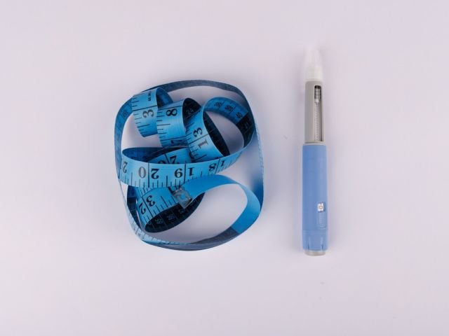 Image of GLP-1 medication next to body tape measure