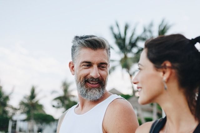 A middle-aged man with healthy cholesterol levels smiles at his partner.