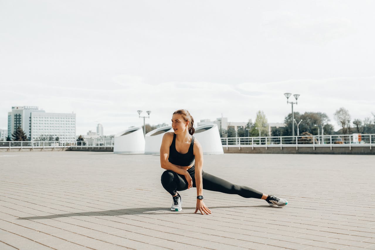 A woman athlete doing stretches on a boardwalk