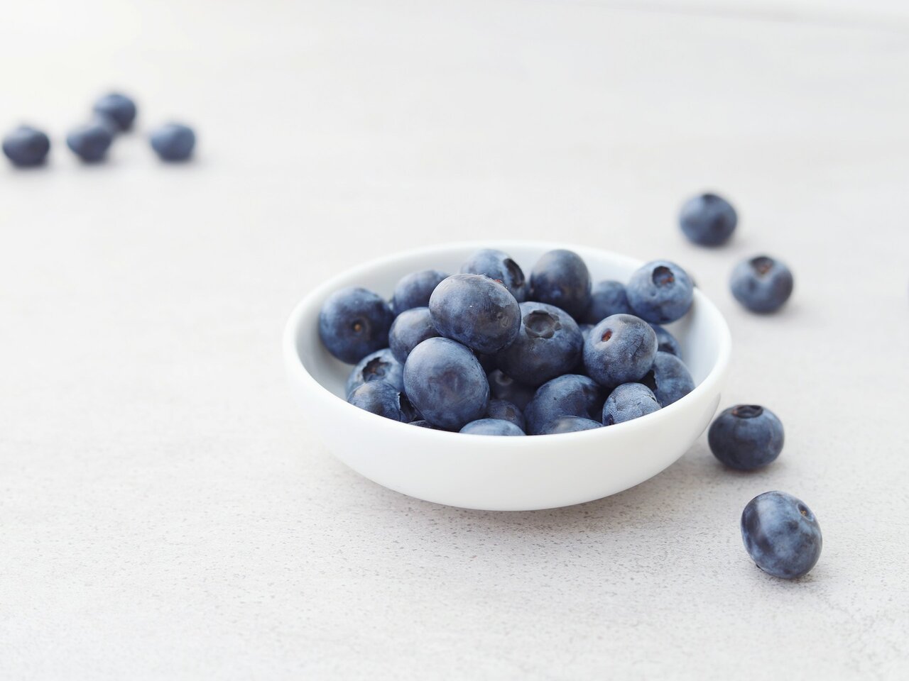 A bowl of blueberries on a white table