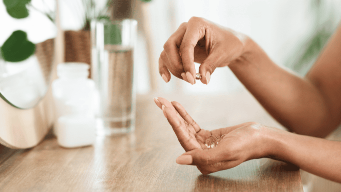 A close-up image of a hand holding supplements