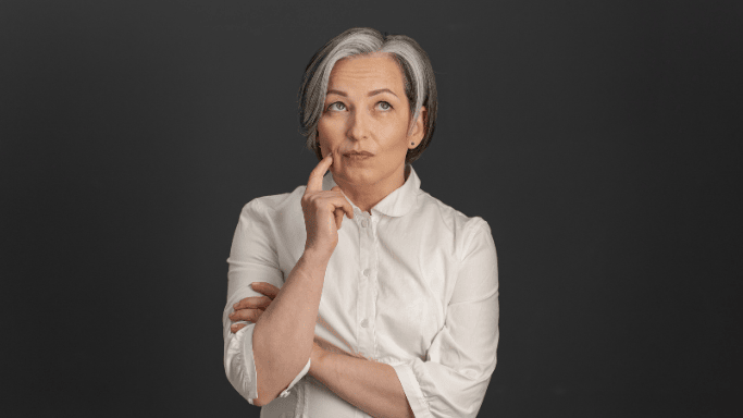 Glutamine vs Creatine: Science-Based Comparison 10 Woman looking up and touching her chin, symbolizing decision-making about supplement choices based on personal health and fitness goals.