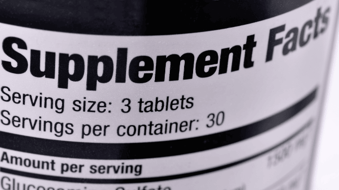 Close-up of a supplement facts label on a bottle, showing serving size of 3 tablets and 30 servings per container