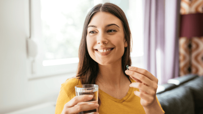 An image of a woman taking supplement