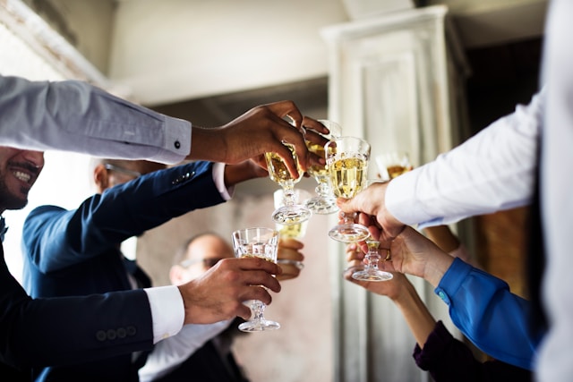A group of friends doing a cheers with alcoholic beverages at a wedding