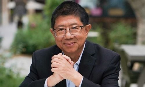 Homepage 46 A photo of Dr. Jin-Xiong She, genomic medicine expert, seated outdoors with his hands clasped